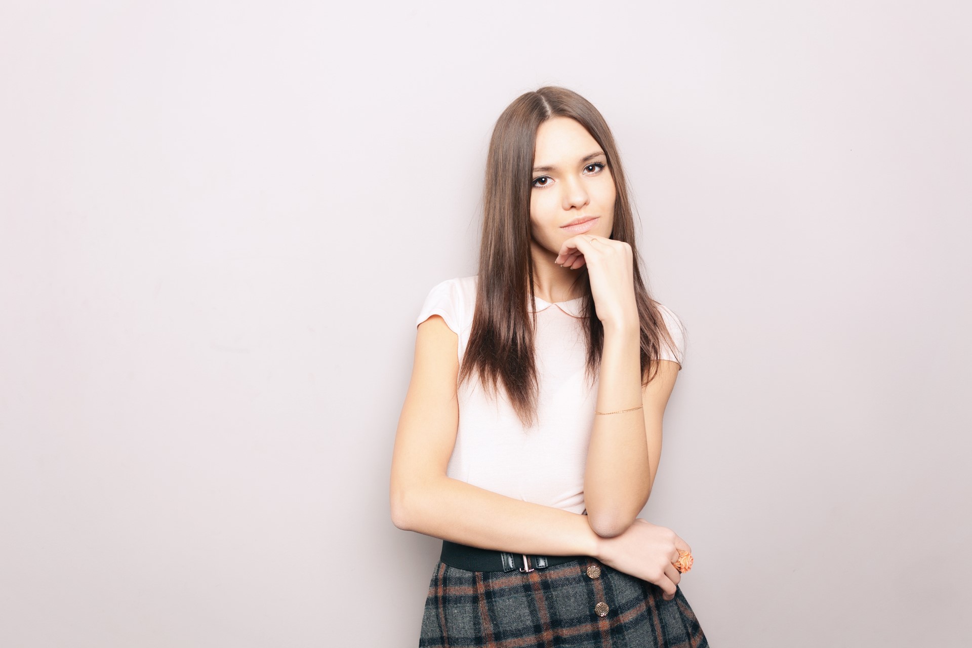 Young thoughtful beautiful brunette woman posing indoors against